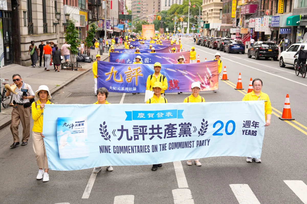 Manifestantes chineses em Nova Iorque andam com um cartaz celebrando os 20 anos da publicação dos Nove Comentários